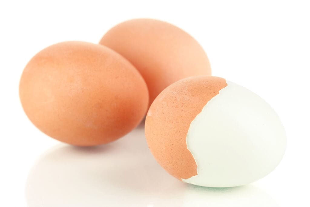 Three hard-boiled eggs sit on a white counter. Eggs are a main ingredient in all recipes with pickled eggs. 